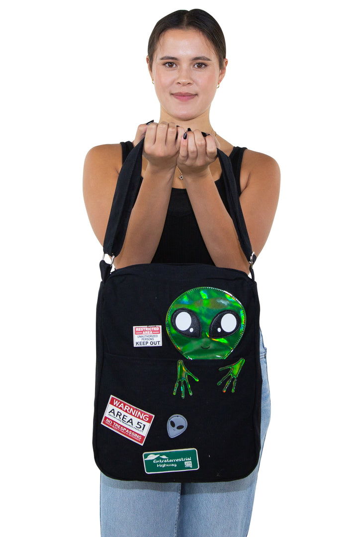 Peeking Alien Canvas Messenger Bag, front view, handheld by model