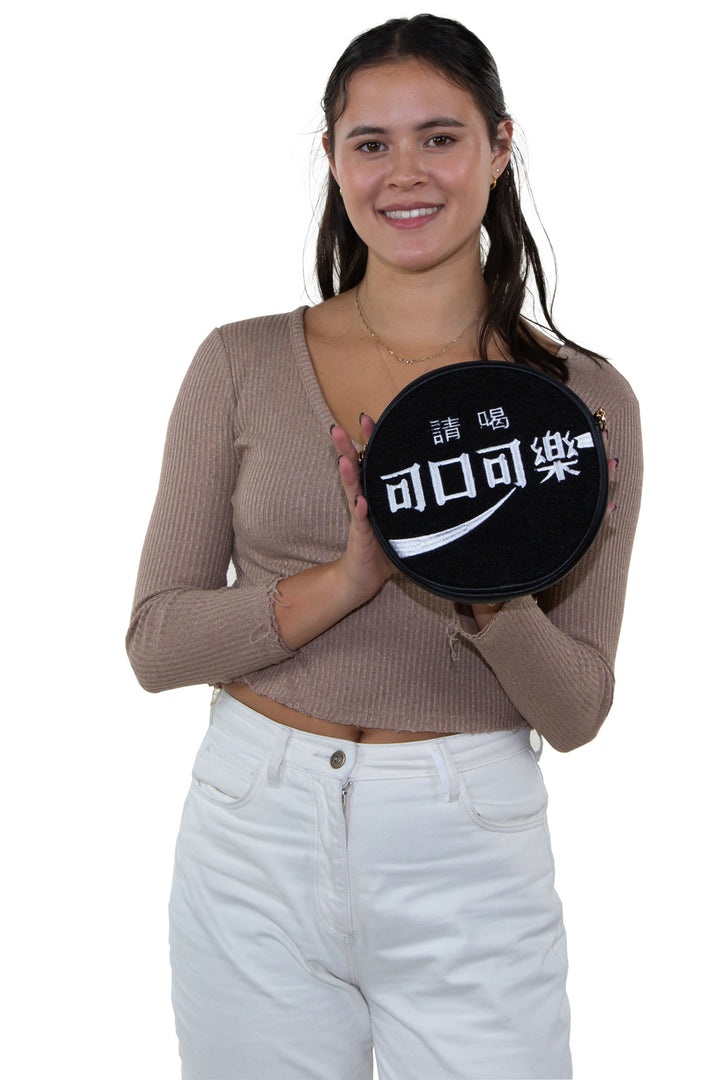 Officially Licensed Coca-Cola Round Disk Chenille Bag, black side, handheld by model
